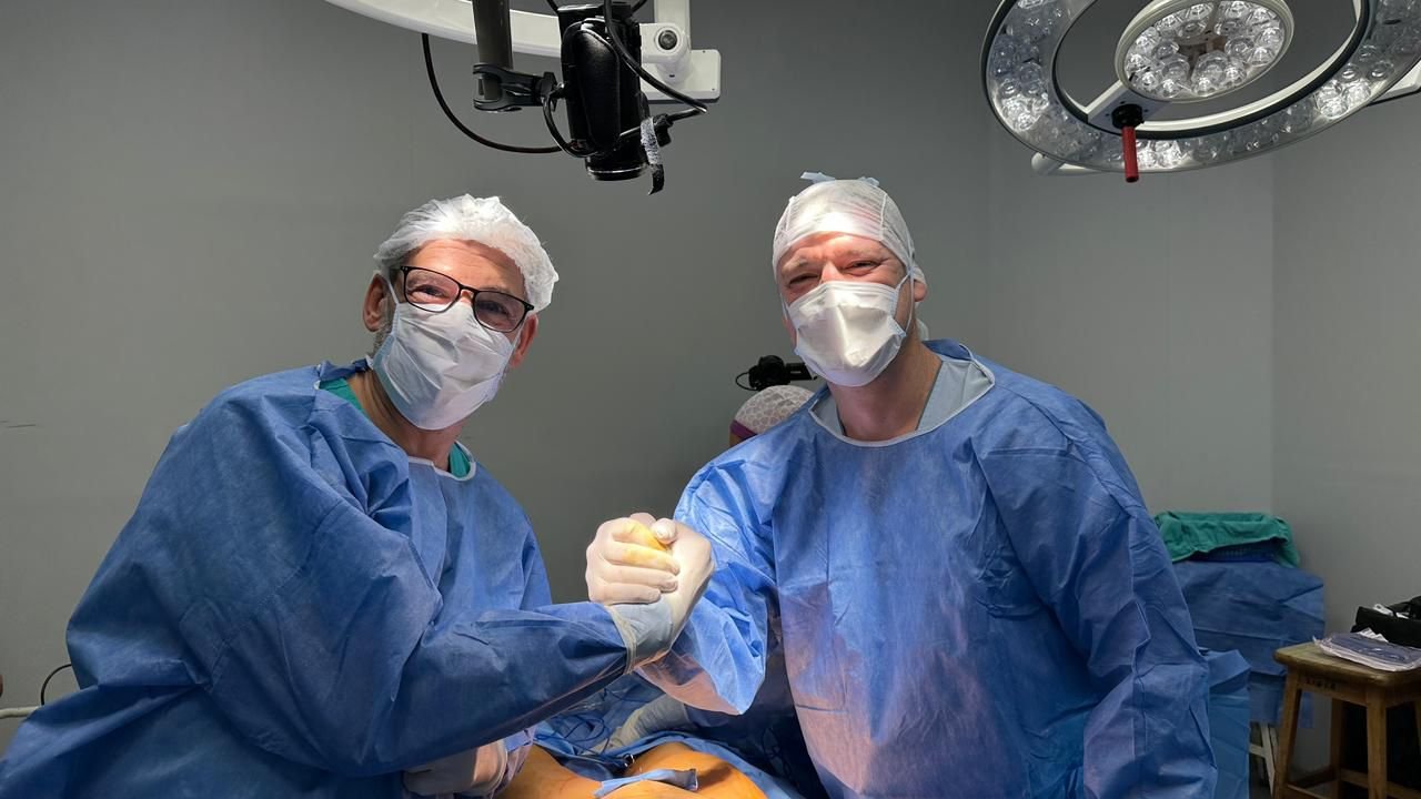 Dr. Gustavo Parera junto a un colega cirujano en quirófano